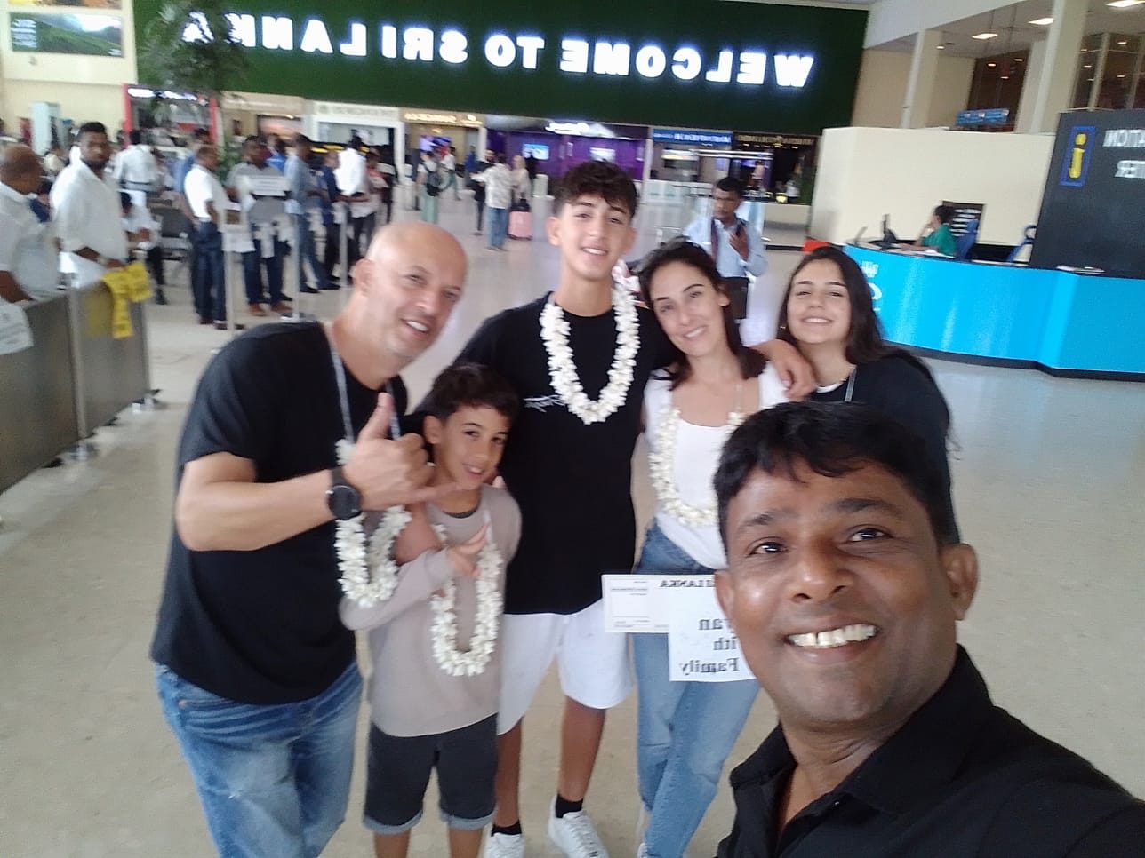 Family with flower garlands greeted by Chin at the airport