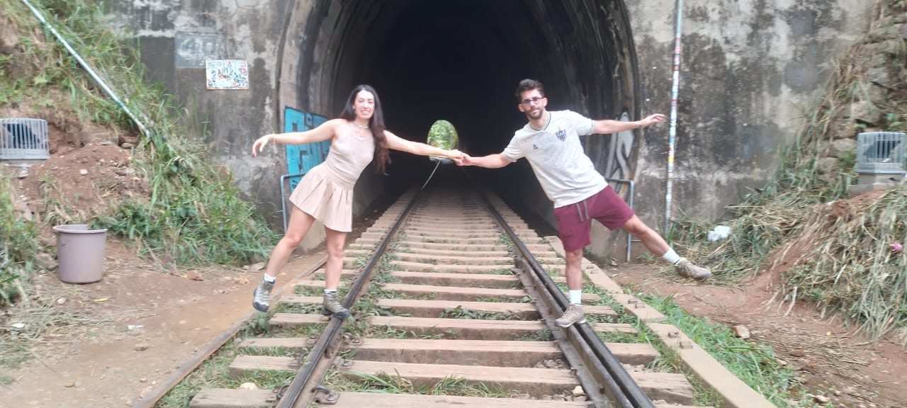 Couple holding hands on the railway tracks at a tunnel