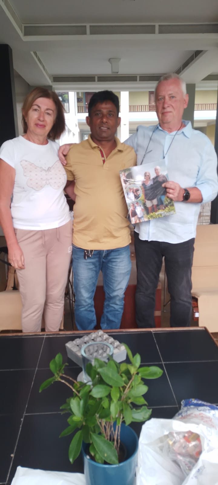Guests with Chin holding a photo book of their trip