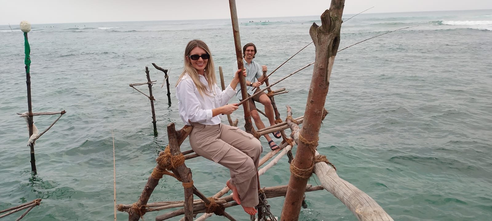 Couple trying stilt fishing in the sea