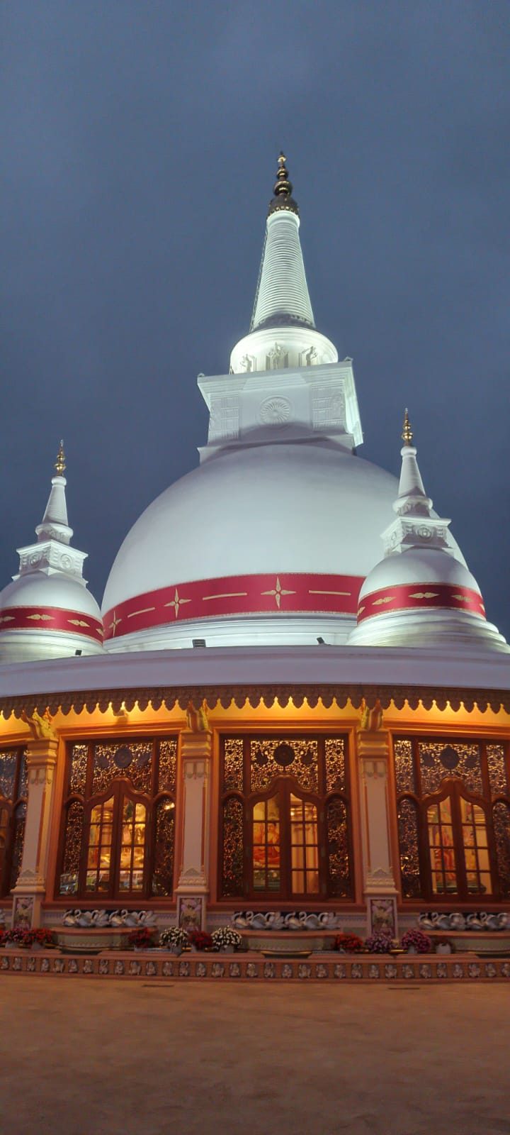 White Buddhist stupa illuminated at night