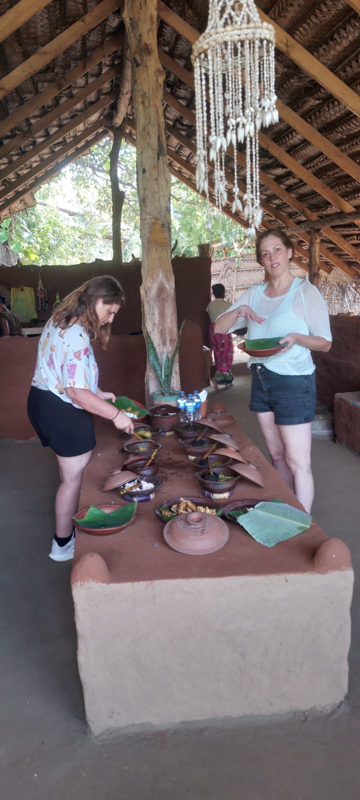 Guests serving themselves a village rice and curry lunch from clay pots