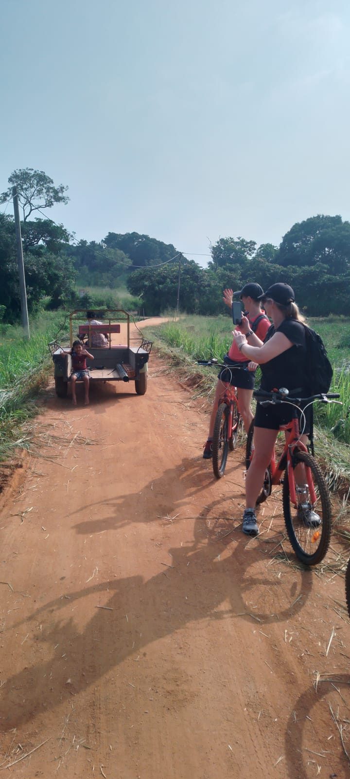 Guests cycling along a red dirt road through the countryside